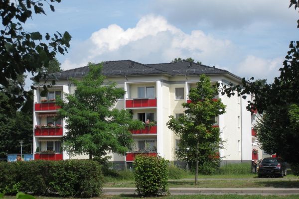 Mehrfamilienhaus mit Wiese und Bäumen